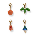 Four colorful beaded charms on gold clasps against a white background