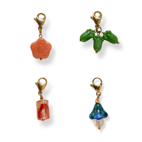 Four colorful beaded charms on gold clasps against a white background